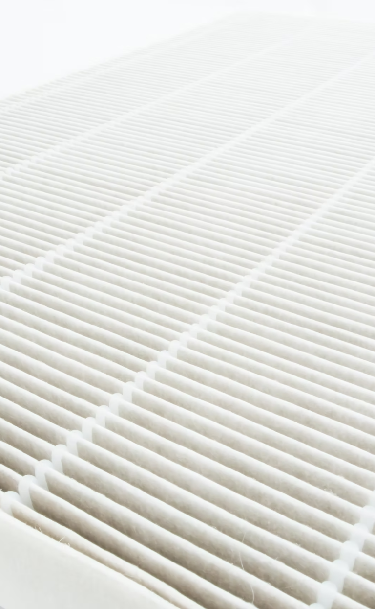 Yanar Haustechnik - Lüftung und Klima Nahaufnahme eines weißen Luftfilters mit parallelen Rillen.